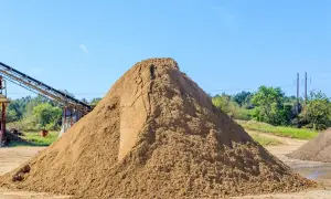 Ogromna hałda piasku na placu budowy. Zastanawiasz się, ile kosztuje tona piasku?