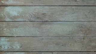 Deska z widoczną sinizną drewna, pokryta wyblakłą, turkusową farbą.